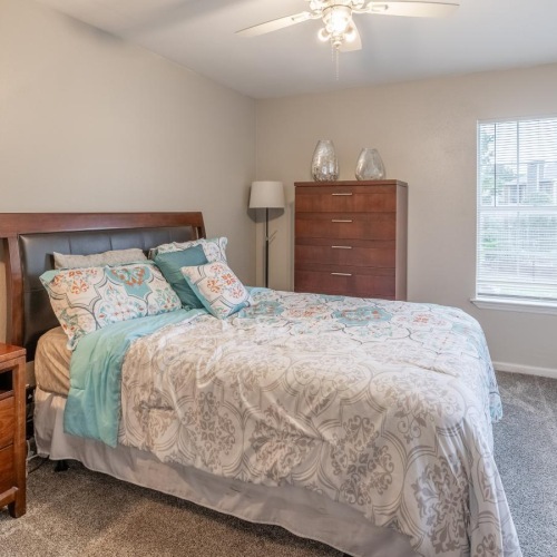a bedroom with a bed and a fan